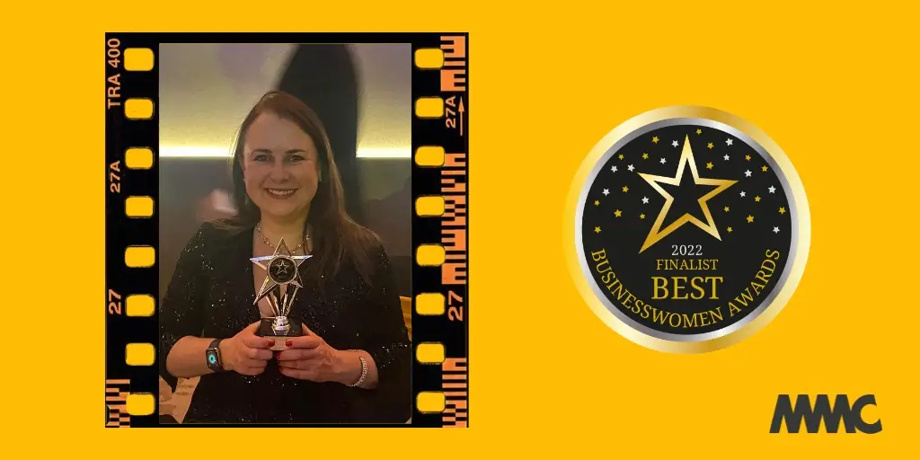 Photo of Natasha holding her award on a background image of yellow alongside the Finalist logo from the event