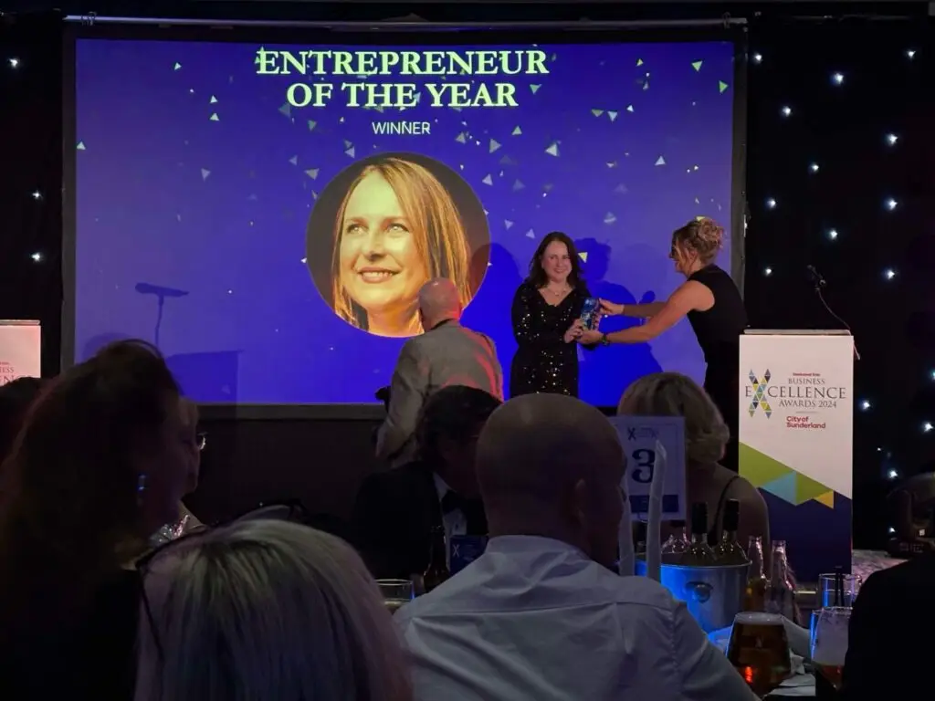 Photo of MMC owner, Natasha, receiving an award on stage